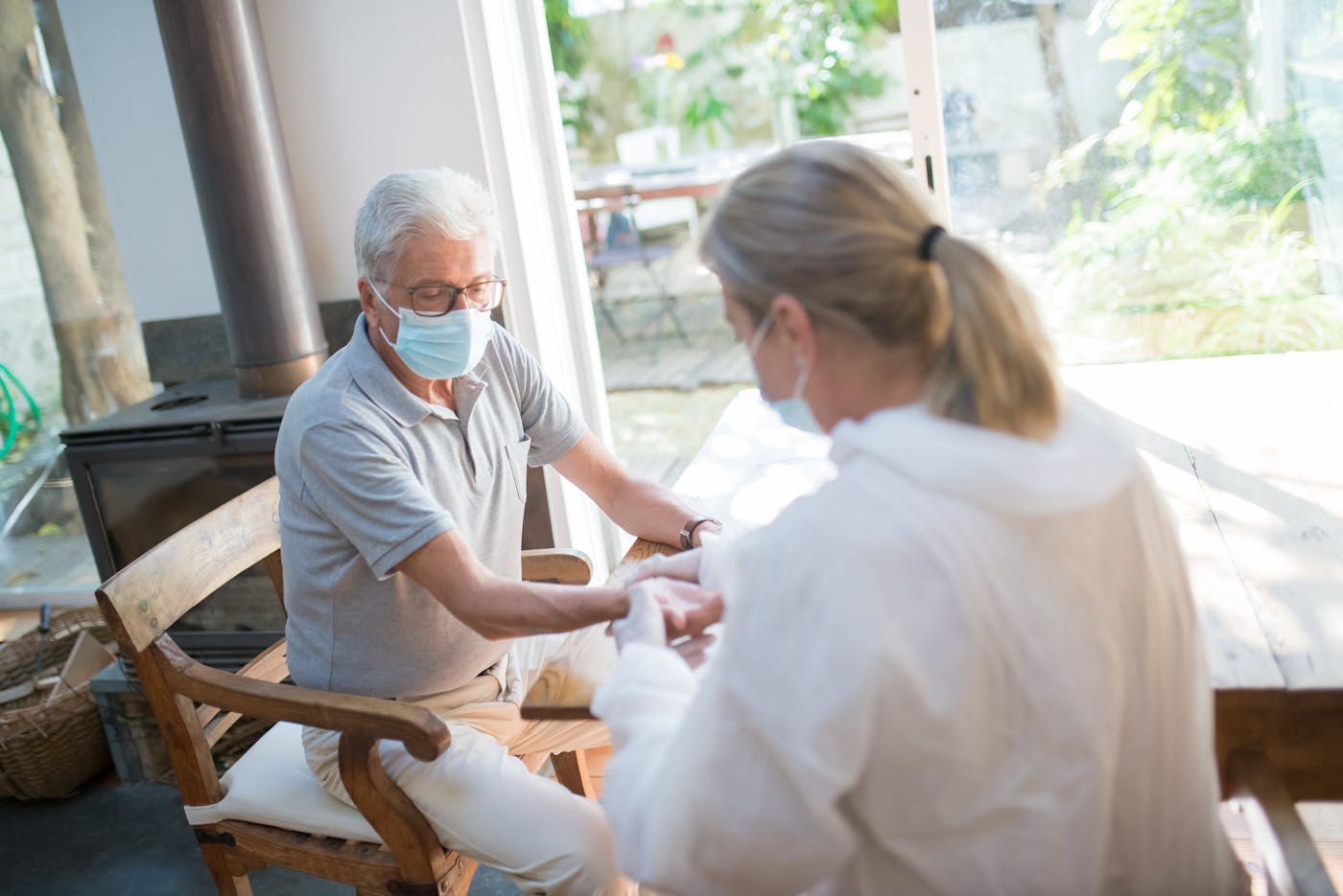Healthcare worker providing personal care to an elderly man at home