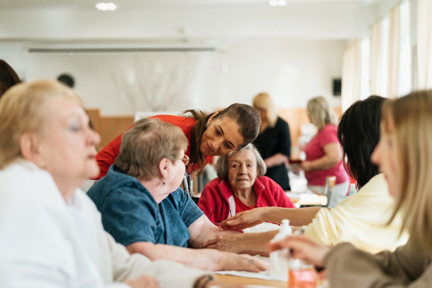 Caregiver engaging warmly with a group of senior clients
