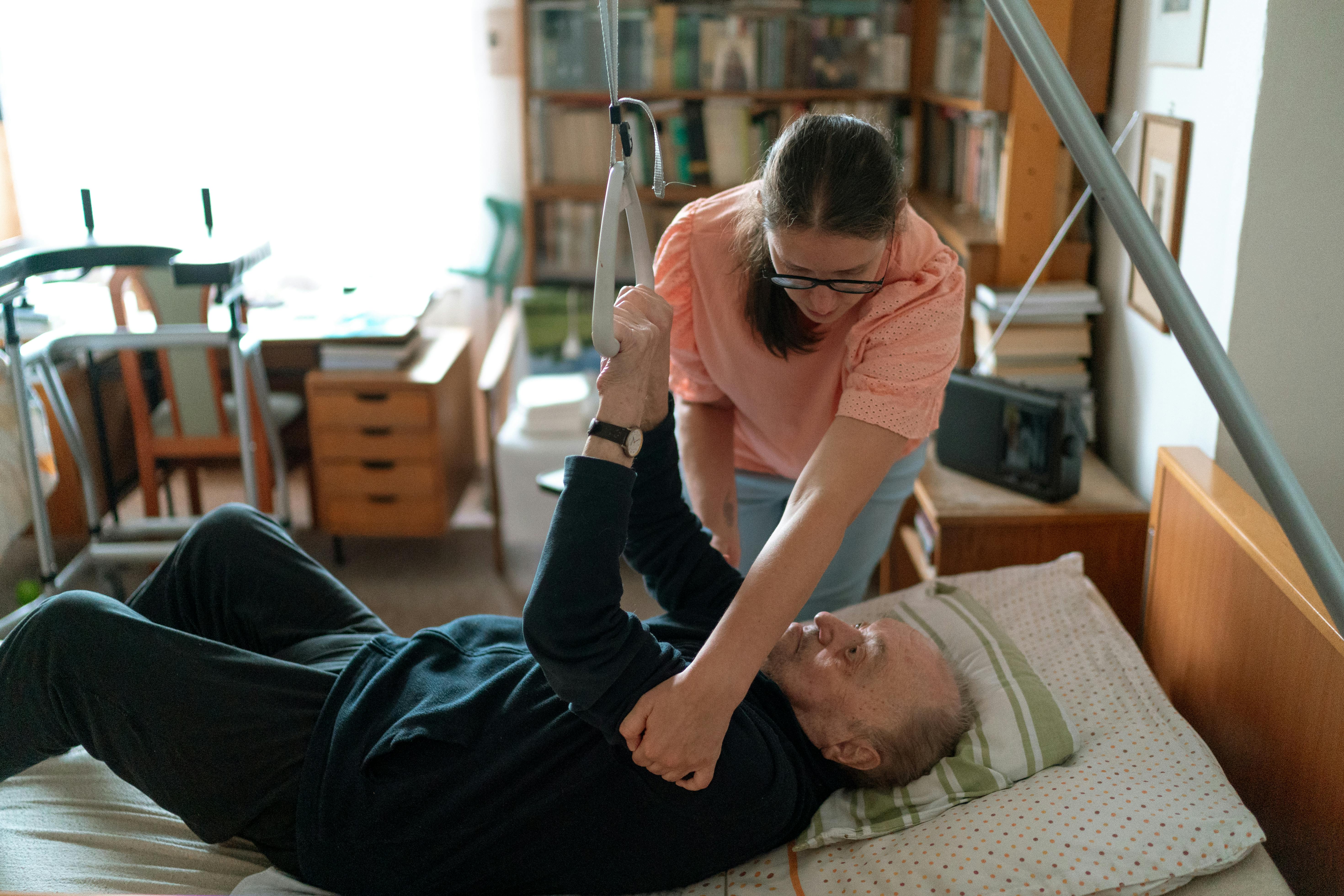 Young carer supporting an elderly man at home