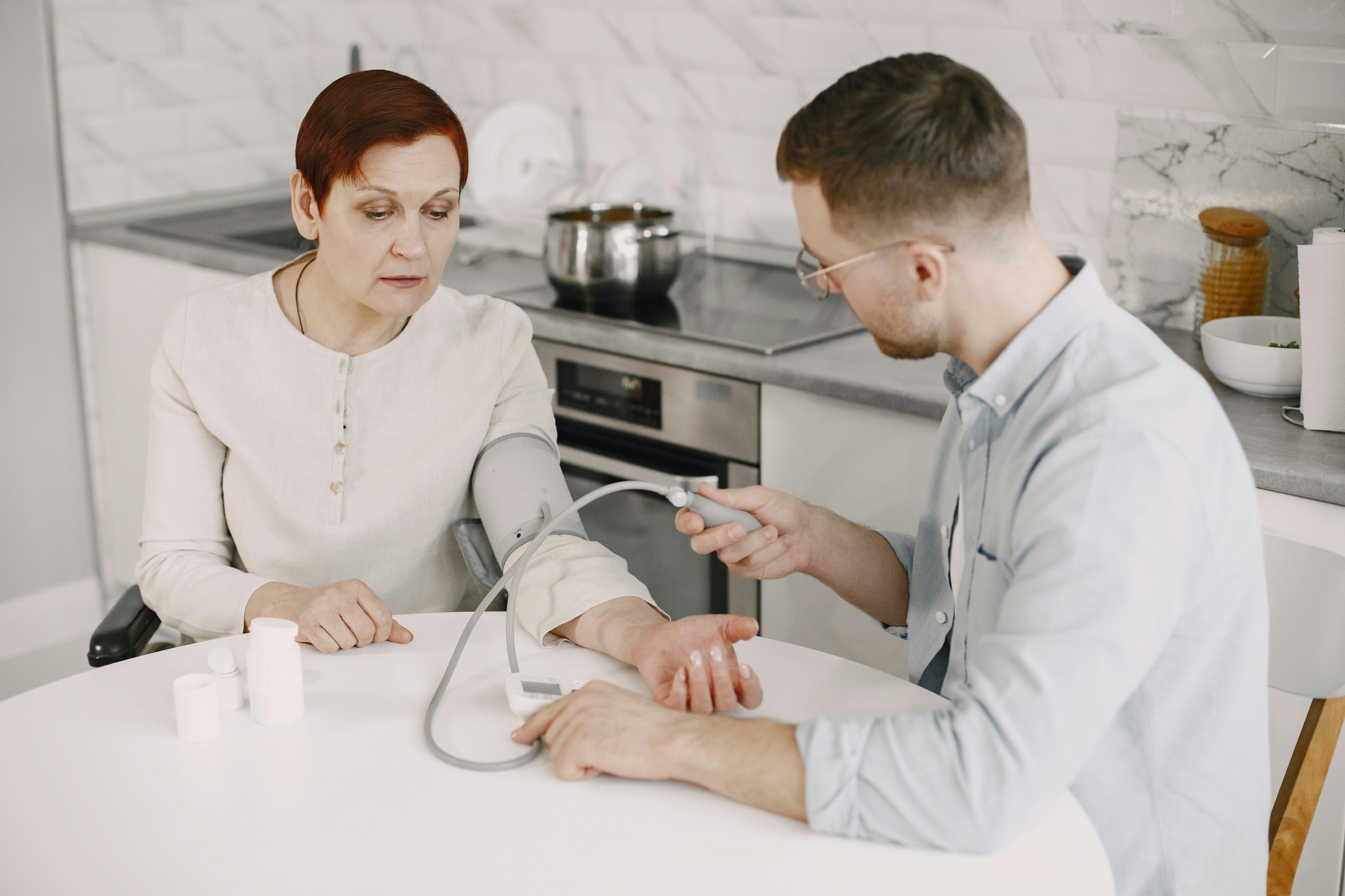 Support worker discreetly helping an elderly man with his medication